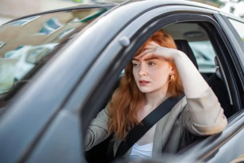 mulher ao volante preocupada em Como Estacionar de Forma Perfeita